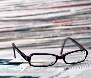 Des coupures de presse et une paire de lunettes