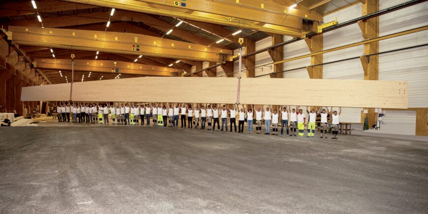 Immense poutre soulevée par les collaborateurs Charpente Fournier